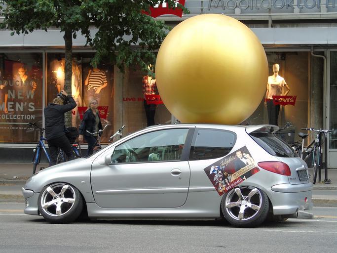Strieborný Peugeot stojí pred obchodom.jpg